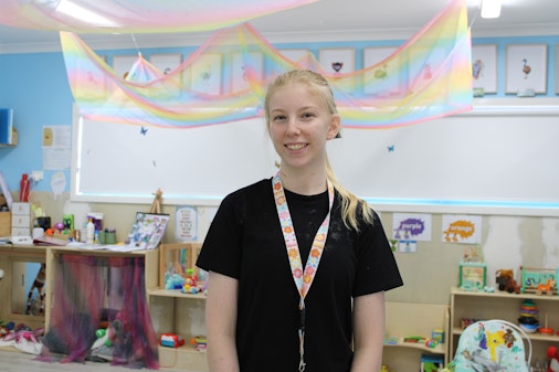 Woman in a black shirt with blonde hair in an early childhood setting.