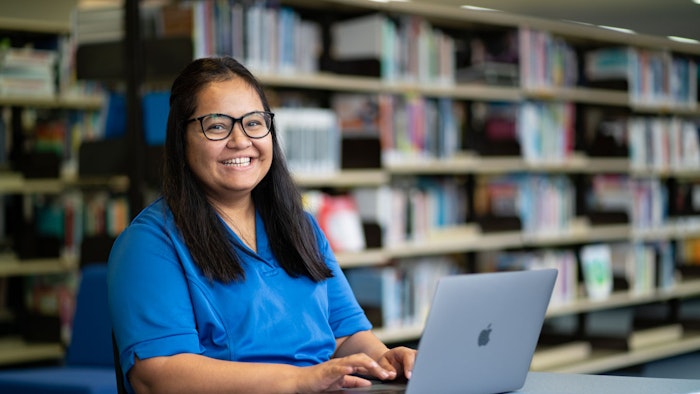 Student sitting at a table with a laptop
