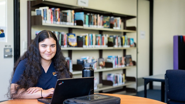 Student sitting at table with her laptop