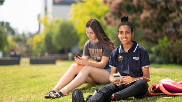 two girls sitting on grass at Fryers Street Campus