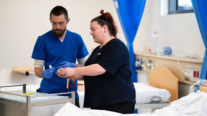 Nursing student and trainer working in classroom