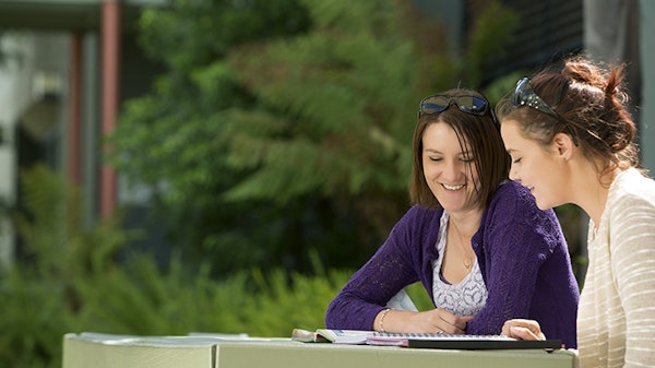 two ladies sitting at a table at Shepparton Campus looking at document